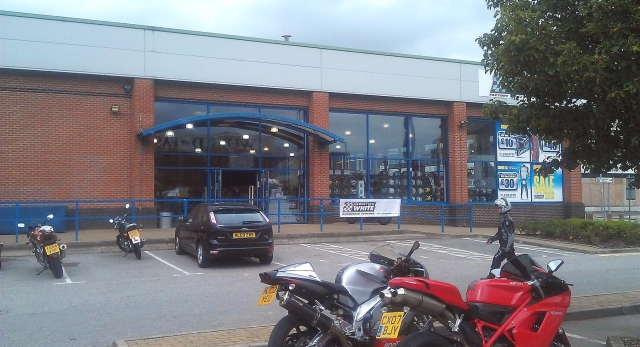 a large shop with a few bikes in the car park, george white's bolton